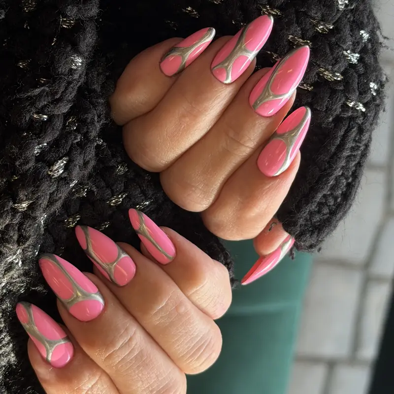 Long almond nails in pink gel with metallic swirl outlines