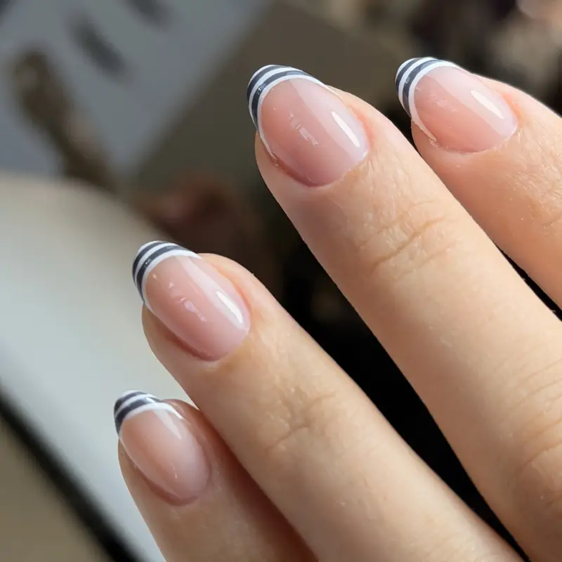 Short natural-looking nails with double-line black and white French tips
